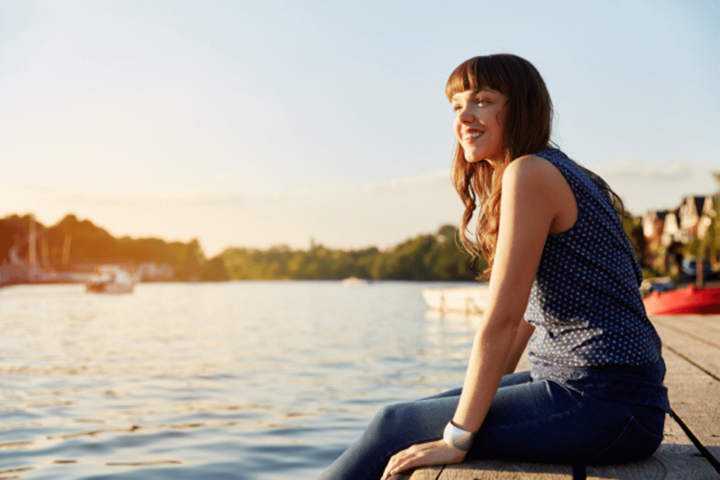 A woman sat on the dock with her legs over the side.