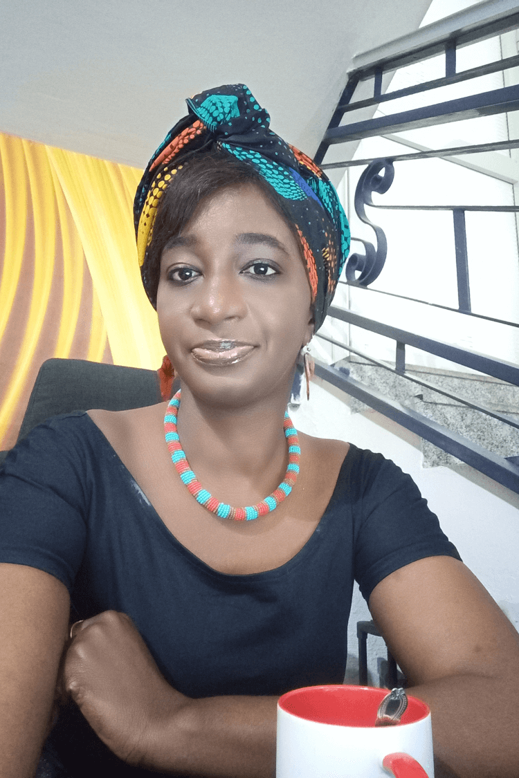 Eine Frau mit blauem Oberteil und mehrfarbigem Kopftuch. 