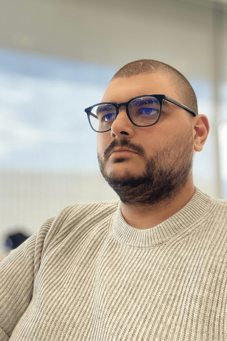 Un homme à lunettes travaillant sur un écran. Il porte des lunettes noires.