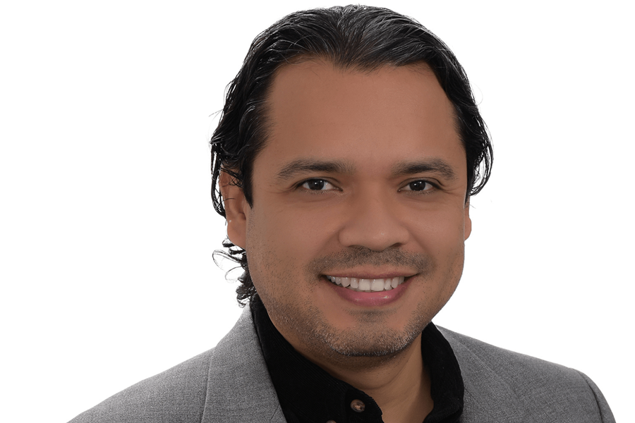 Un homme portant une chemise sombre et une veste grise