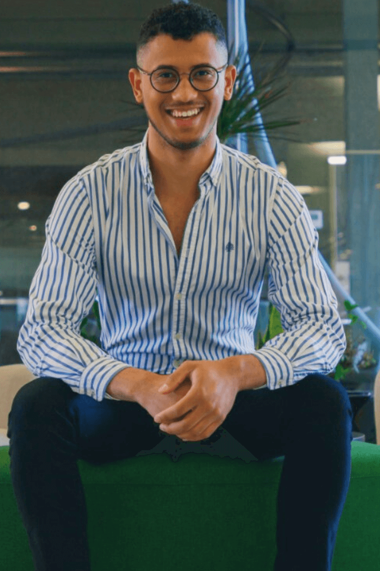 Een man zat op een bankje met een blauw shirt aan. 